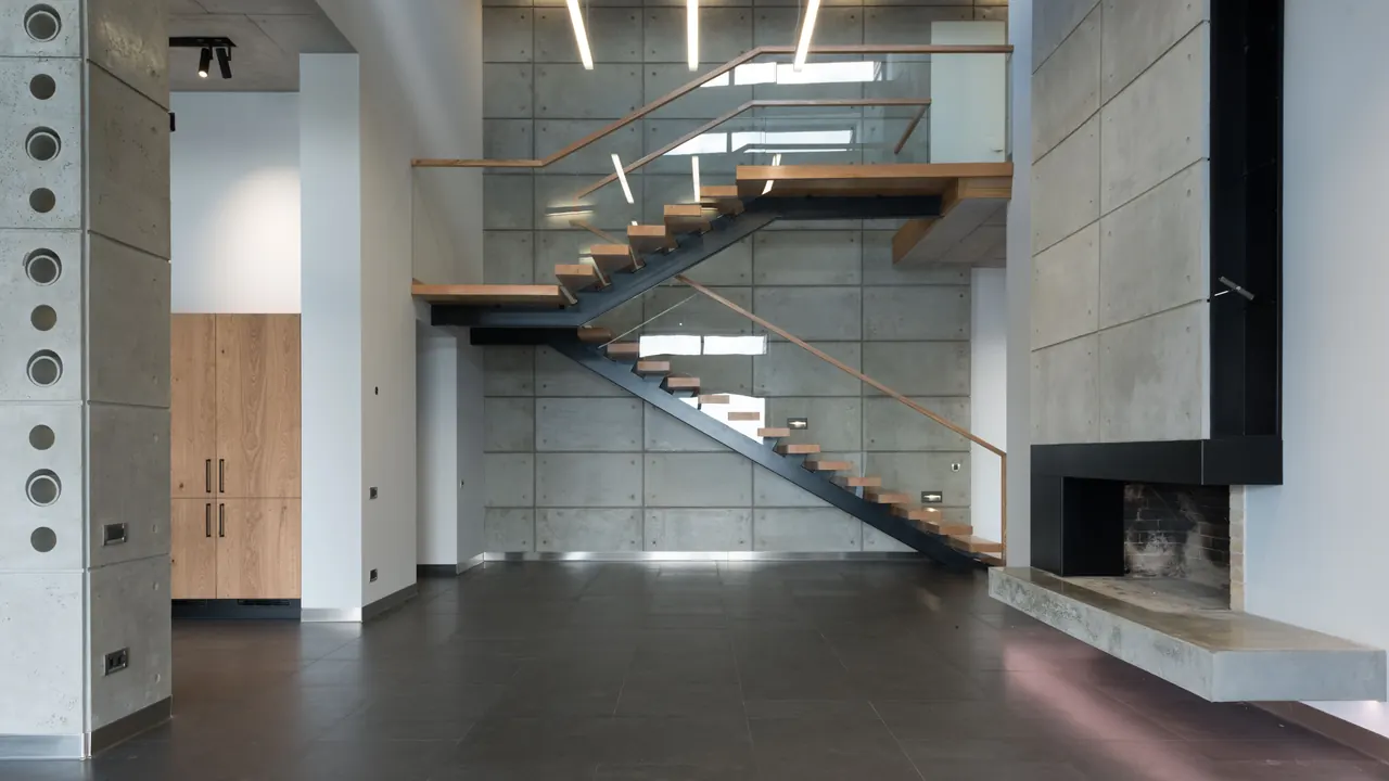 Escalier en bois sur mesure dans une maison contemporaine, marches et limon visibles.