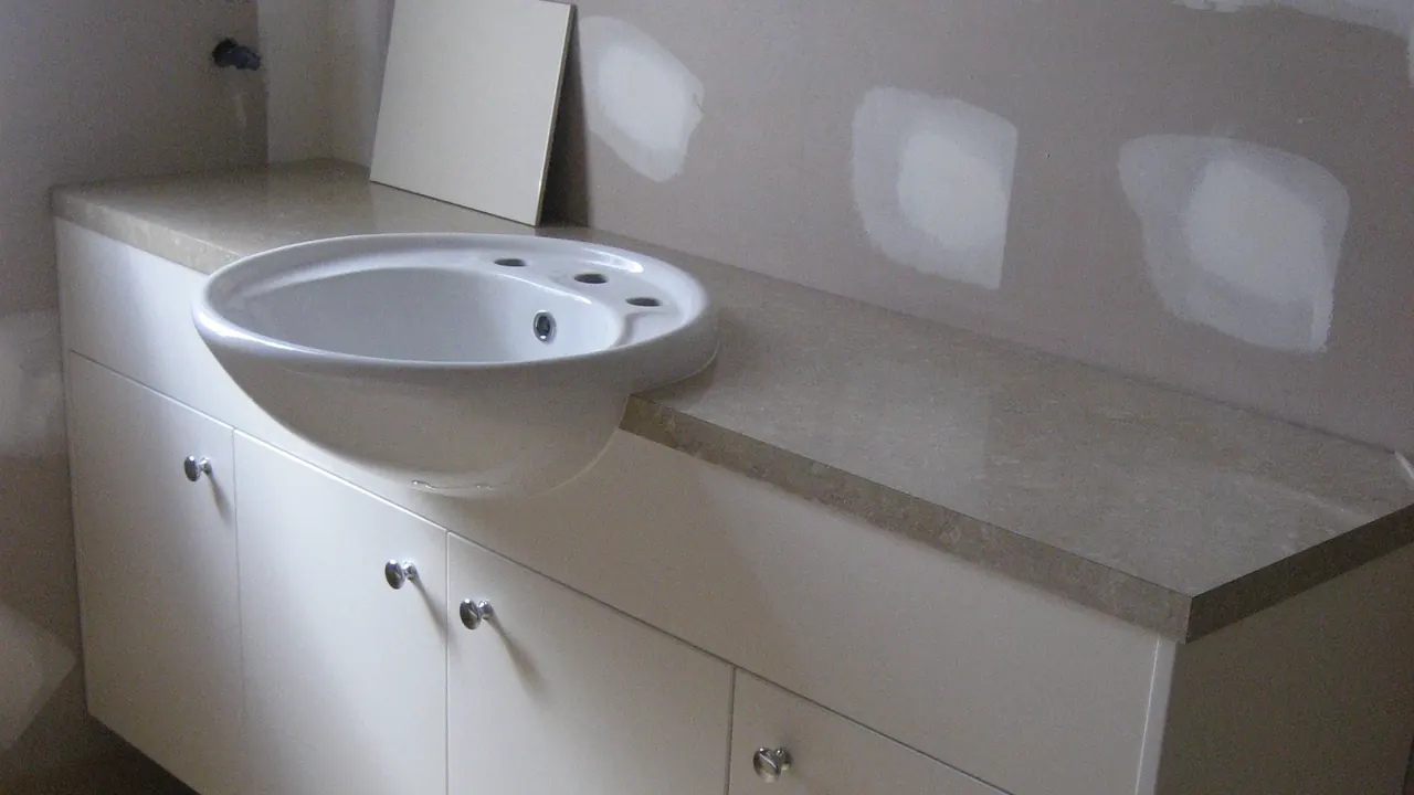 Salle de bain photographiée pendant les travaux, meuble posé et murs encore bruts
