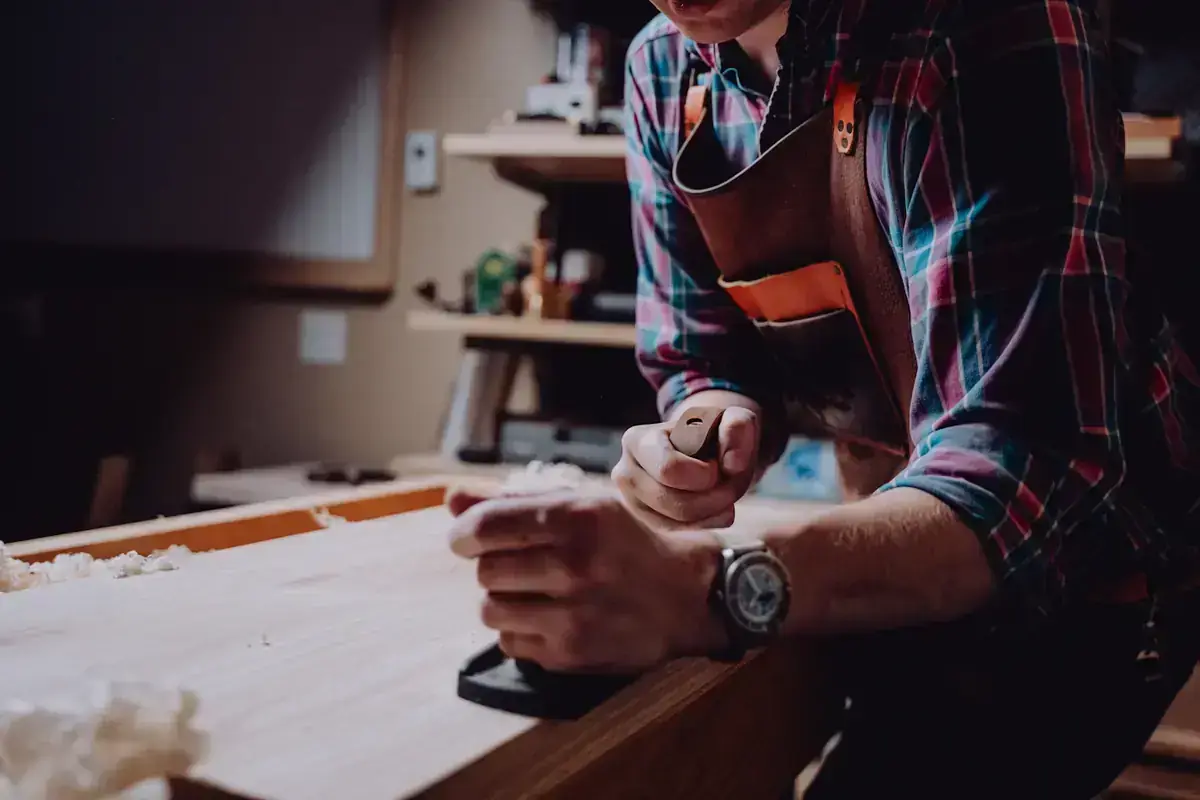Ébéniste qui rabote une planche