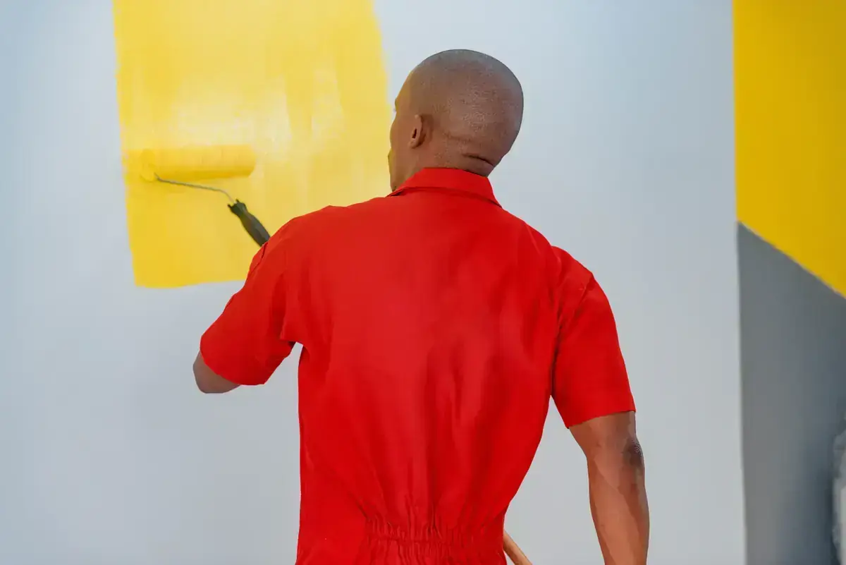 Peintre qui passe un rouleau jaune