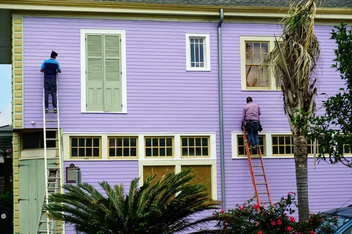 Peintres sur échelle devant une façade